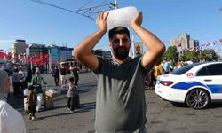 Taksim’de sıcaktan bunalan simit satıcısı buz kalıbıyla serinledi